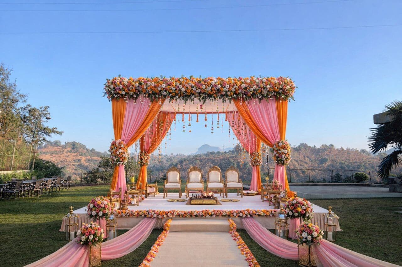 Wedding mandap stage with pink and orange floral decor at Manas Resort